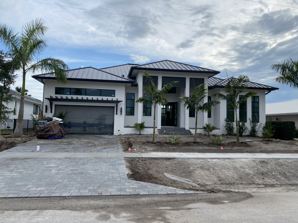 The home nearly complete, with driveway pavers and new palms