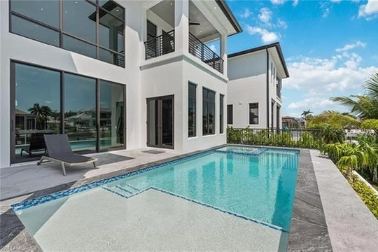 Modern two-story home with a pool and glass walls