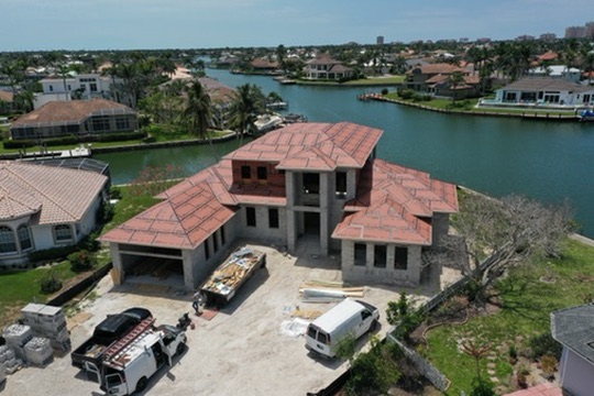 Aerial of the block structure with roof underlayment and crews on site