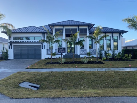 Finished white custom home with metal roof on Old Marco Lane, Marco Island